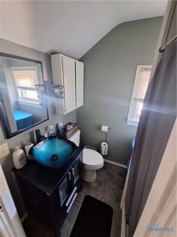 bathroom featuring vanity, lofted ceiling, toilet, and tile patterned floors