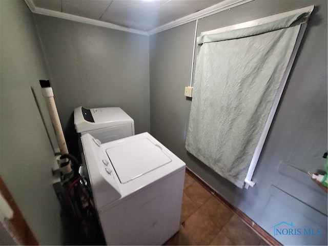 washroom with ornamental molding, separate washer and dryer, and dark tile patterned floors