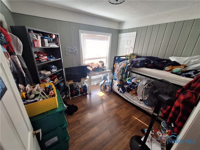 bedroom featuring a textured ceiling and dark hardwood / wood-style floors