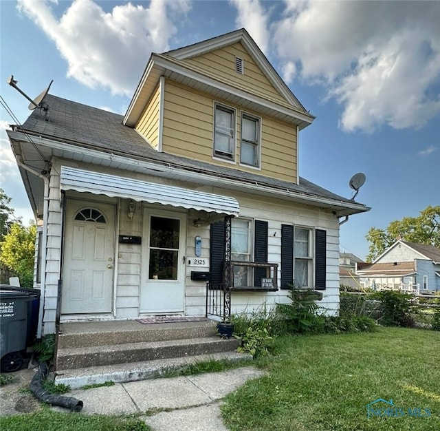 view of front of property with a porch and a front lawn