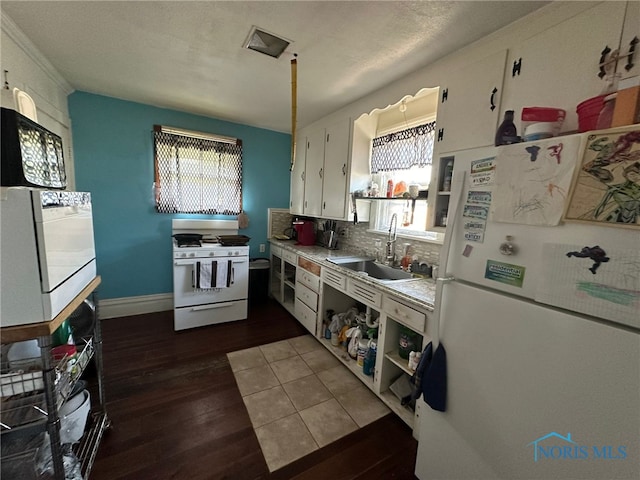 kitchen with white cabinets, white appliances, a wealth of natural light, and sink