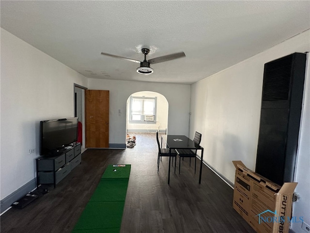 rec room with ceiling fan, a textured ceiling, and dark hardwood / wood-style floors