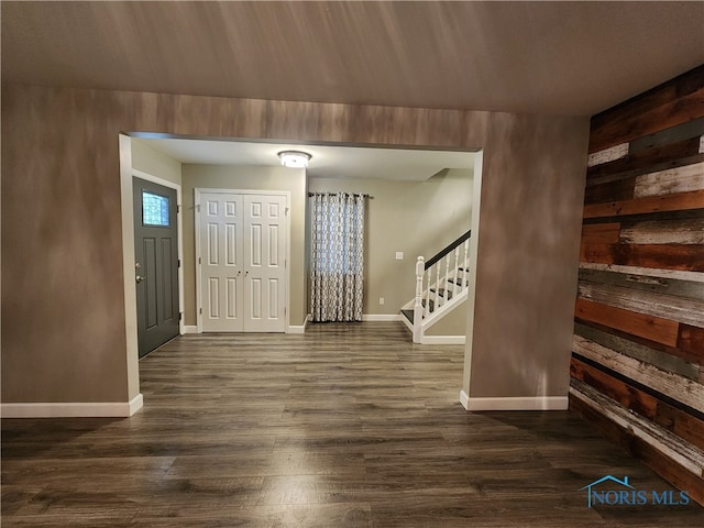 entrance foyer featuring dark hardwood / wood-style floors and wood walls