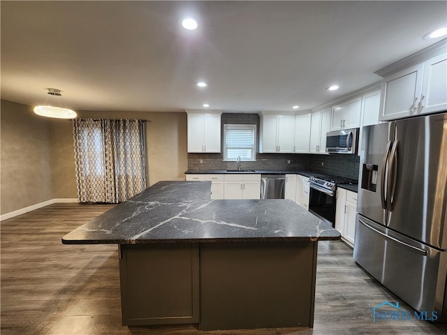 kitchen with a center island, dark wood-type flooring, sink, white cabinets, and stainless steel appliances