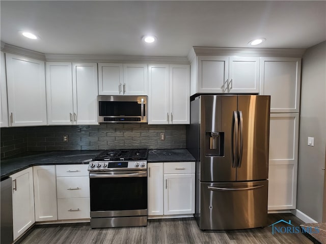 kitchen with stainless steel appliances, backsplash, and white cabinetry