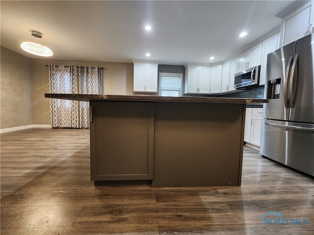 kitchen with a kitchen island, stainless steel appliances, and white cabinetry