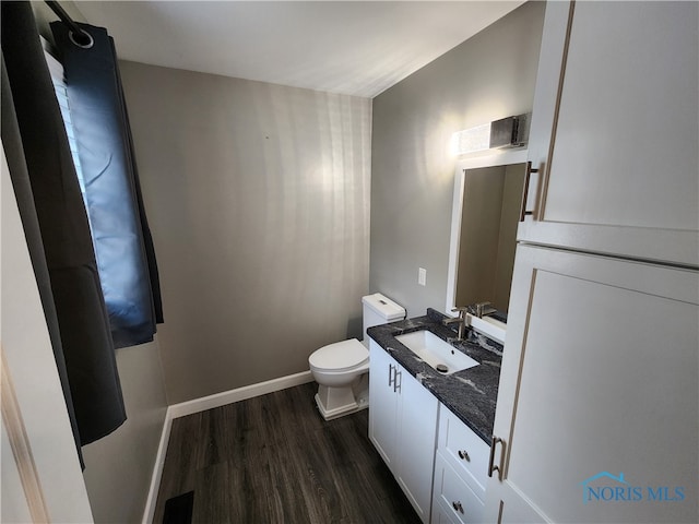 bathroom with hardwood / wood-style floors, vanity, and toilet