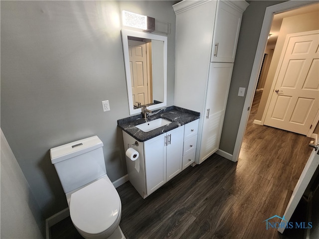 bathroom with vanity, toilet, and hardwood / wood-style flooring