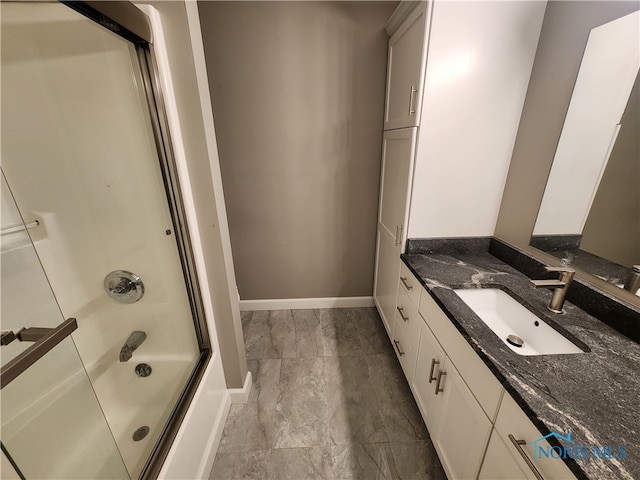 bathroom featuring bath / shower combo with glass door and vanity