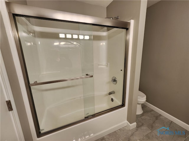 bathroom featuring tile patterned flooring, shower / bath combination with glass door, and toilet