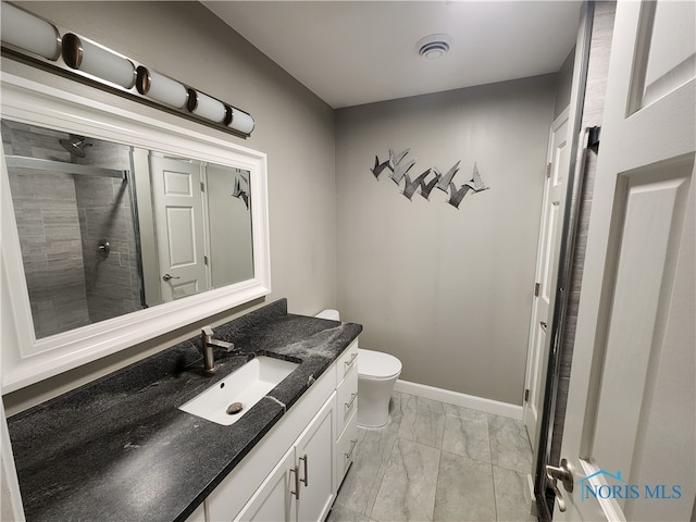 bathroom featuring walk in shower, vanity, and toilet