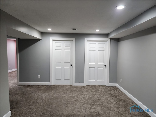 basement featuring dark colored carpet