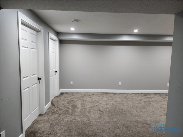 basement featuring carpet floors and a textured ceiling