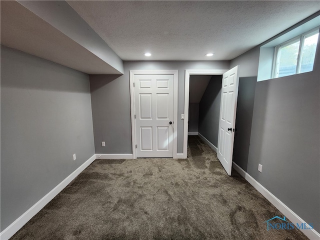 basement with a textured ceiling and carpet flooring