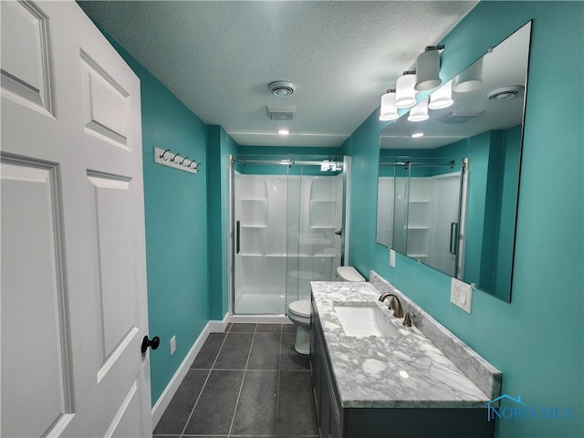 bathroom with vanity, tile patterned flooring, a textured ceiling, a shower with shower door, and toilet