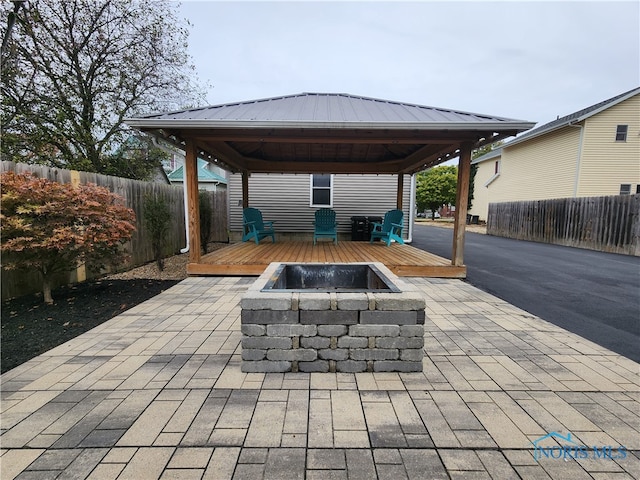 view of patio / terrace with a deck, a gazebo, and an outdoor fire pit