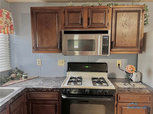 kitchen featuring white range with gas cooktop and sink