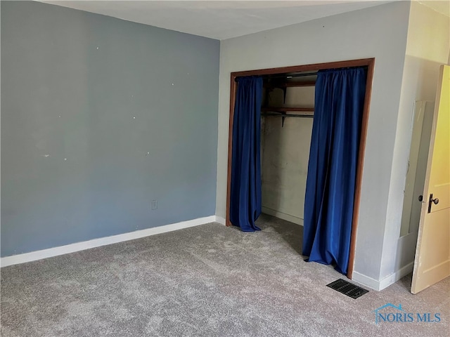 unfurnished bedroom with carpet floors and a closet