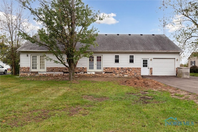 exterior space featuring french doors, a front yard, and a garage