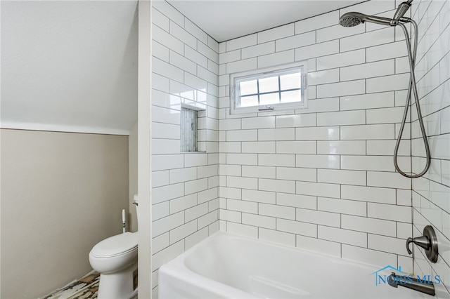 bathroom featuring tiled shower / bath combo and toilet