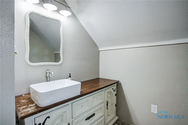 bathroom with vanity and vaulted ceiling