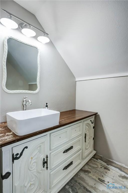 2915 N 109th St, Toledo, OH 43611 - bathroom featuring lofted ceiling, vanity, and wood finished floors