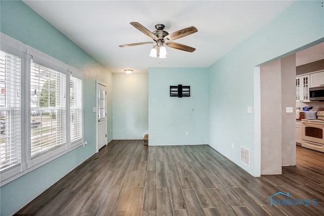 spare room featuring ceiling fan and dark wood-type flooring