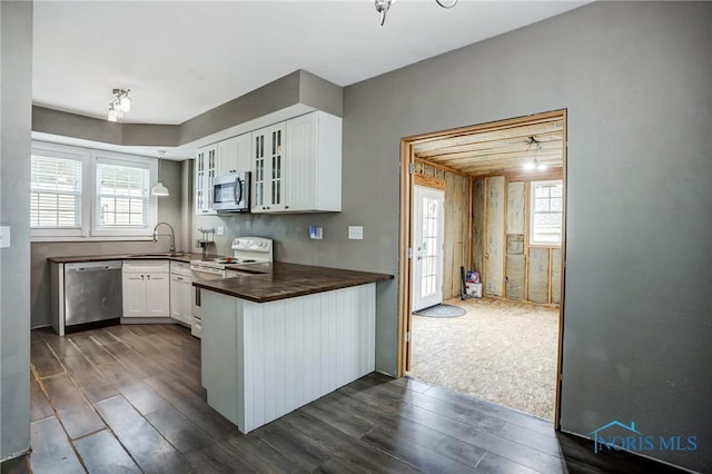2915 N 109th St, Toledo, OH 43611 - kitchen featuring appliances with stainless steel finishes, a sink, dark wood-style floors, glass insert cabinets, and white cabinetry