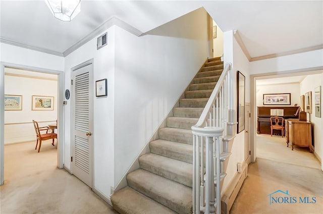 staircase featuring carpet and ornamental molding