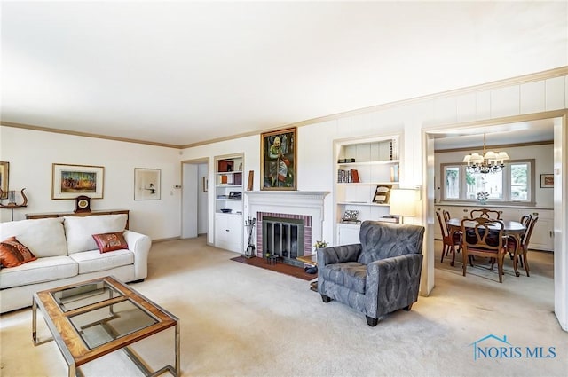 carpeted living room featuring built in shelves, an inviting chandelier, ornamental molding, and a brick fireplace