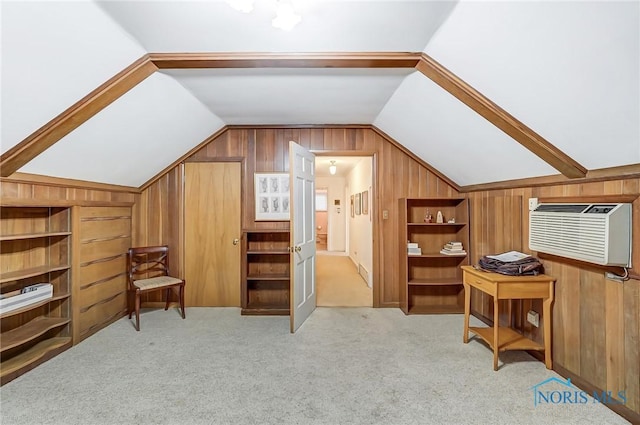 bonus room with a wall unit AC, built in shelves, light colored carpet, and vaulted ceiling