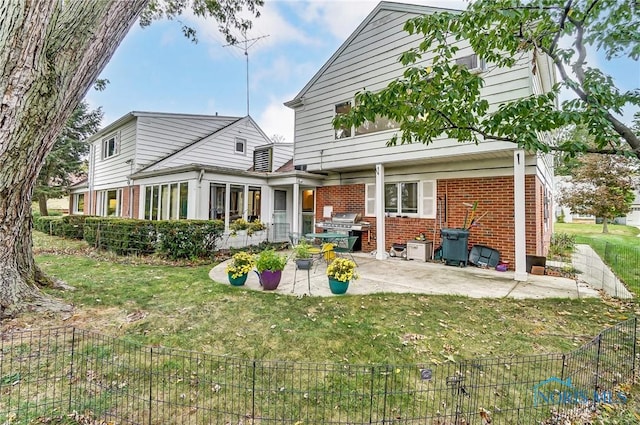 back of property featuring a lawn and a patio area