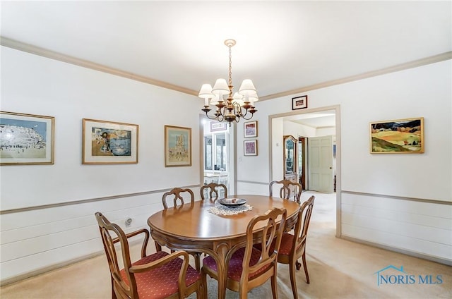 dining space with a notable chandelier, crown molding, and light carpet