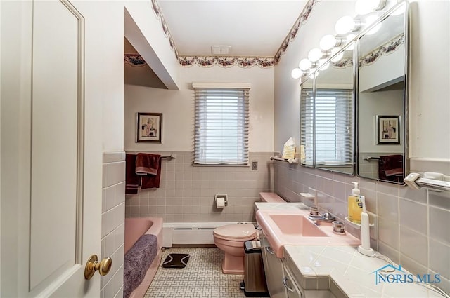 bathroom featuring a bathtub, a baseboard radiator, tile walls, tile patterned flooring, and toilet