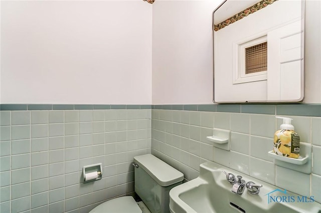 bathroom featuring toilet and tile walls