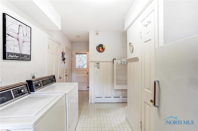 clothes washing area with independent washer and dryer and a baseboard heating unit