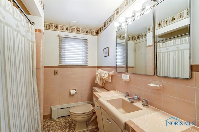 bathroom featuring a baseboard heating unit, tile patterned floors, toilet, vanity, and tile walls