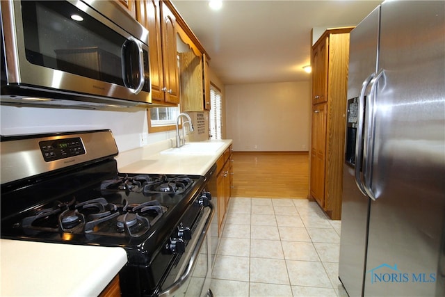 kitchen featuring stainless steel appliances, sink, and light tile patterned floors