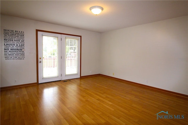 unfurnished room with hardwood / wood-style floors