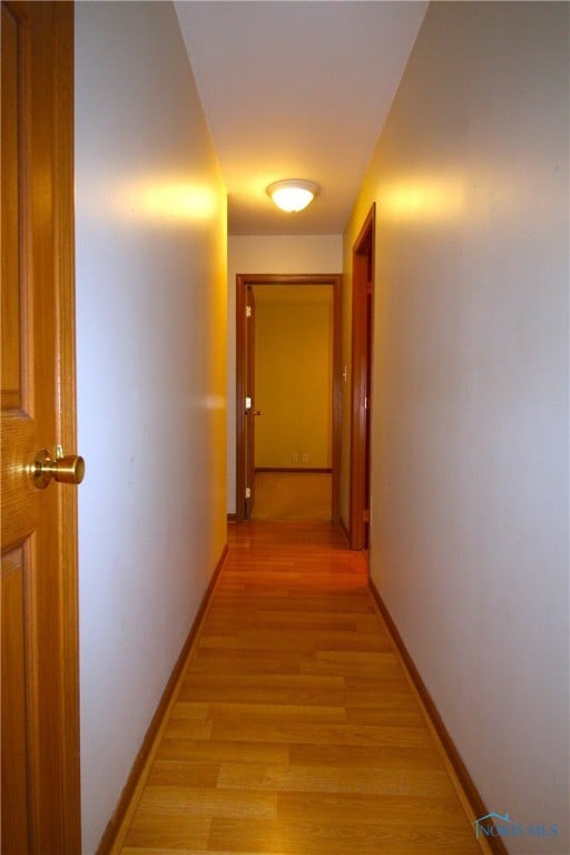 hallway with light hardwood / wood-style floors