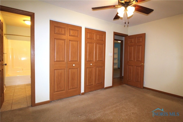 unfurnished bedroom with ceiling fan, light carpet, and ensuite bath