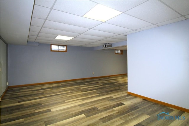 basement with dark hardwood / wood-style floors and a drop ceiling