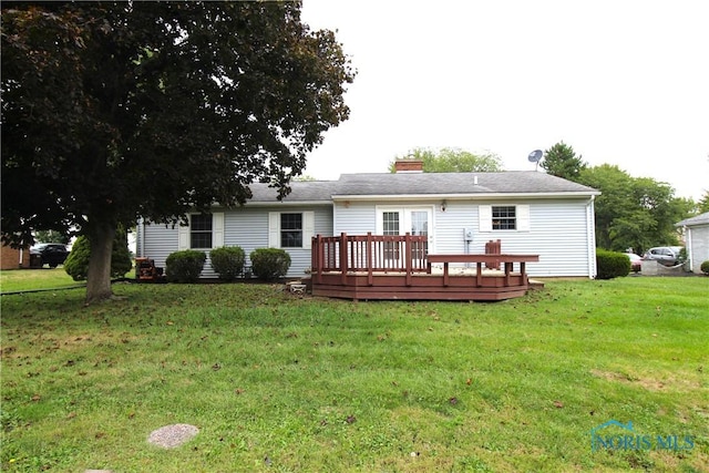 back of property with a yard and a deck