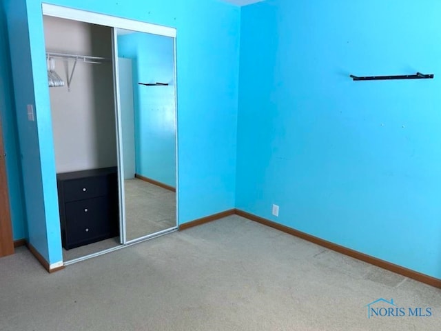 unfurnished bedroom with a closet and carpet flooring