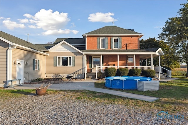 rear view of property with a porch and a patio area