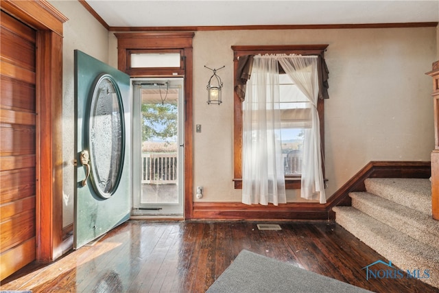 doorway with crown molding and dark hardwood / wood-style flooring