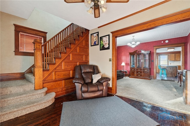 living room featuring dark wood-type flooring and ceiling fan with notable chandelier