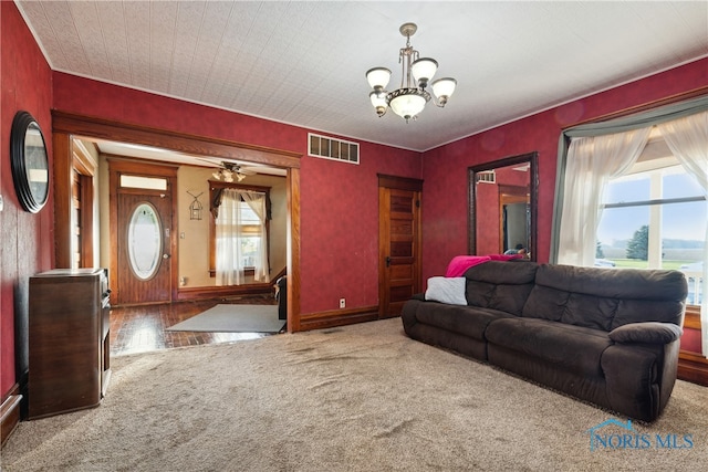 living room featuring carpet floors and ceiling fan with notable chandelier