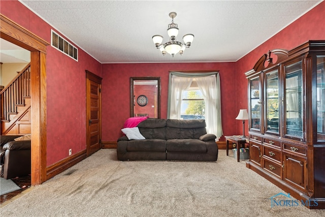 carpeted living room featuring a textured ceiling and a chandelier