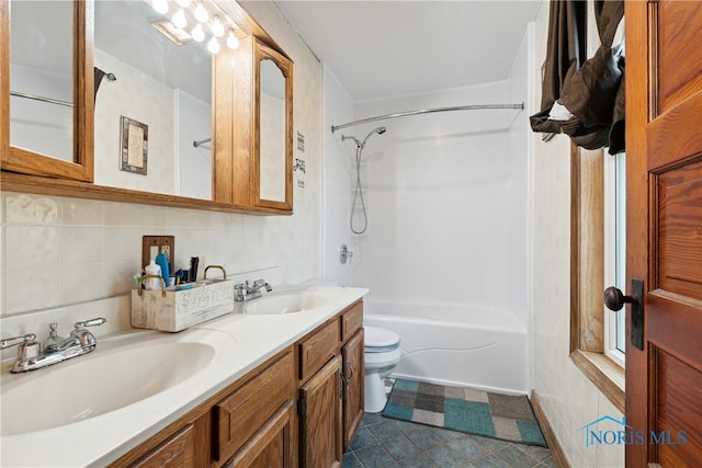 full bathroom featuring vanity, toilet, tile walls, and shower / tub combination